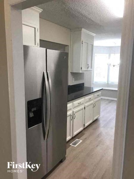 a kitchen with a stainless steel refrigerator and white cabinets