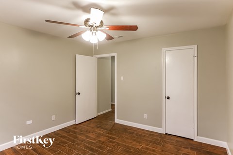 a bedroom with a ceiling fan and a closet