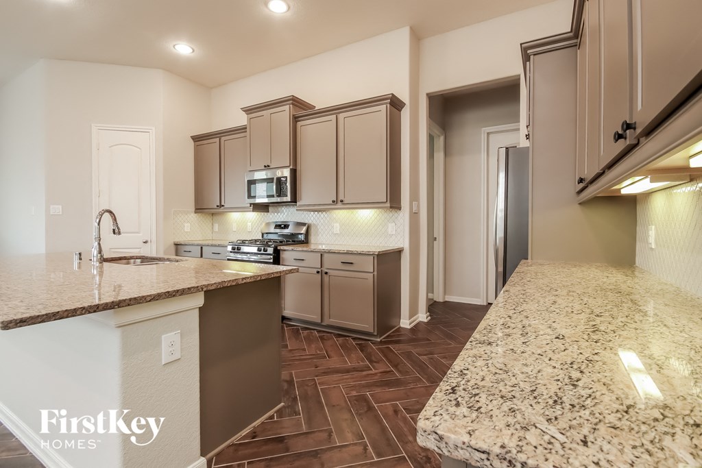 a kitchen with granite countertops and stainless steel appliances