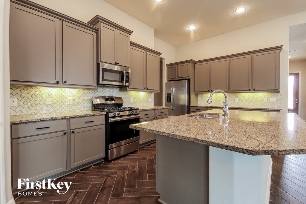 a kitchen with granite countertops and stainless steel appliances