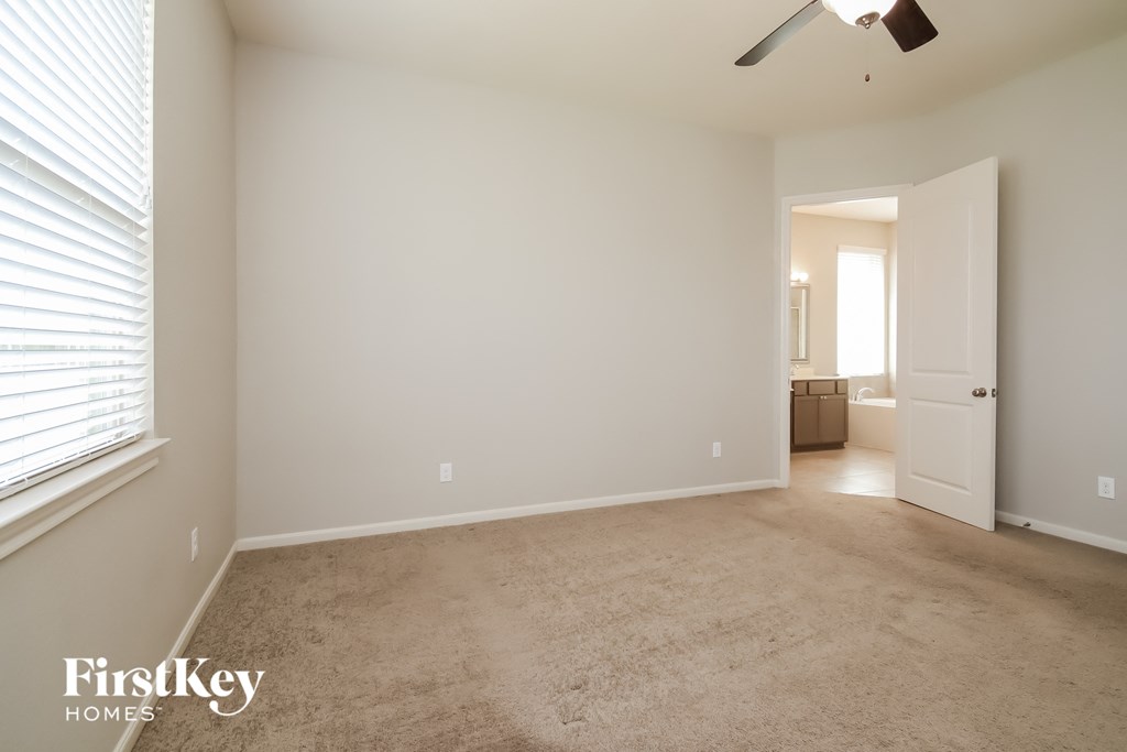 a living room with a carpeted floor and a large window
