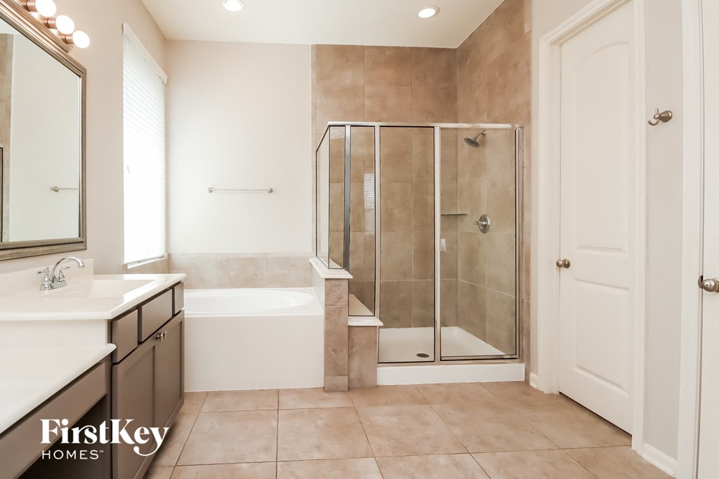 a bathroom with a shower and a tub and two sinks