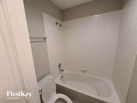 a white bathroom with a tub and a toilet