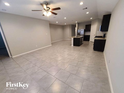 a large living room with tile flooring and a ceiling fan