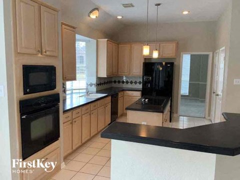 a large kitchen with a black counter top