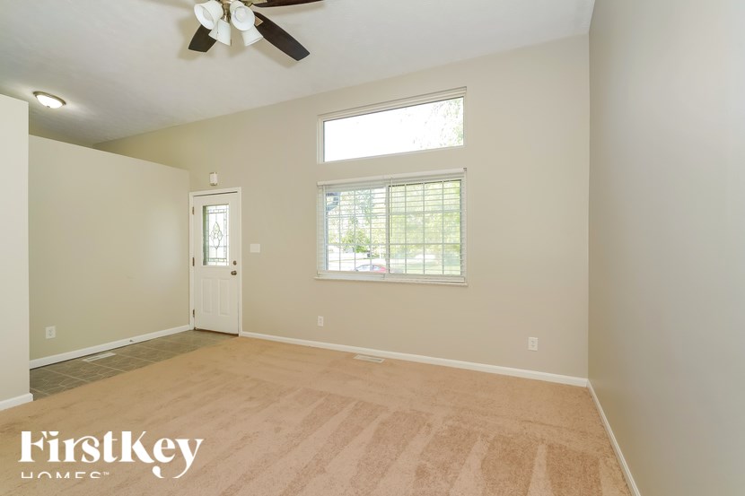 A room with a ceiling fan and a window with blinds.