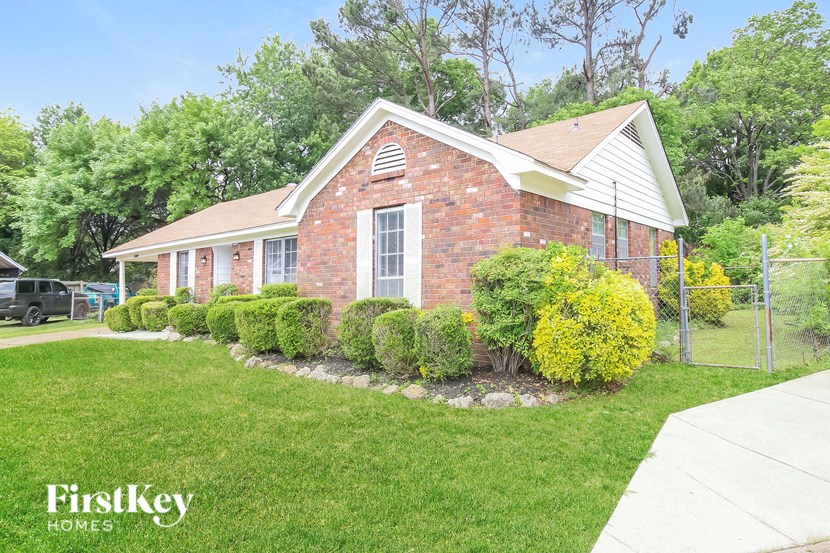 A brick house with a white window and a small porch.