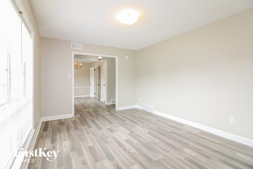 A room with wooden flooring and a doorway leading to another room.