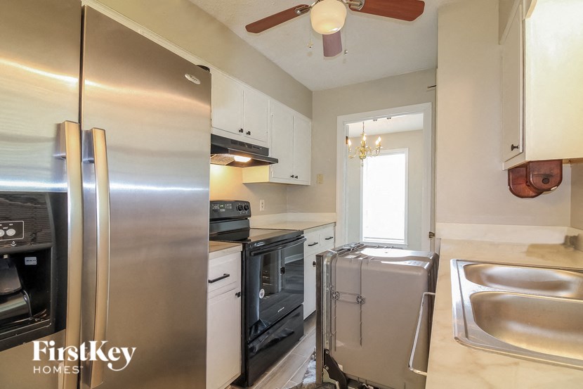 A kitchen with a stainless steel refrigerator and a stainless steel sink.