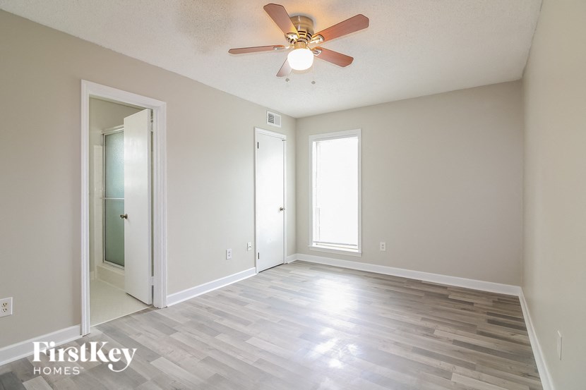 A room with a ceiling fan and wooden flooring.
