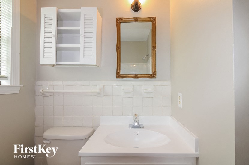 A bathroom with a white sink and a mirror above it.