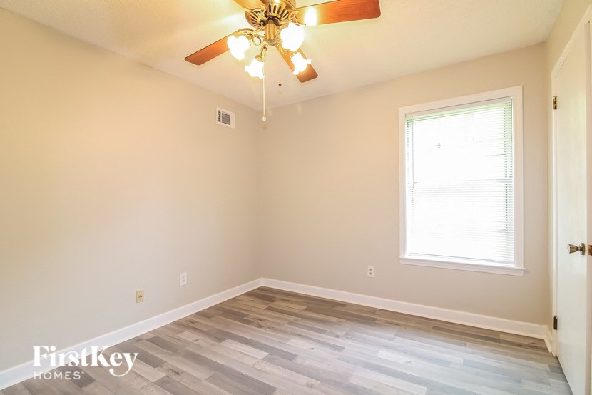 A room with a ceiling fan and a window.