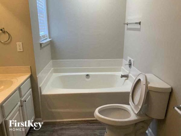 a bathroom with a toilet and a tub and a sink