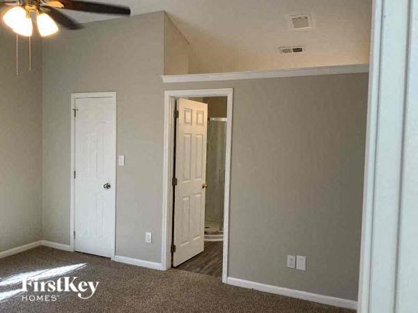 an empty room with a ceiling fan and a door