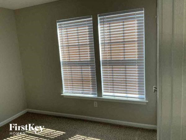 a room with two windows and blinds on the wall