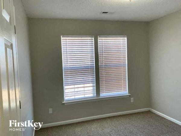 an empty room with two windows and a door