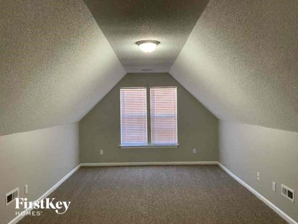 an empty attic with a window and a ceiling light