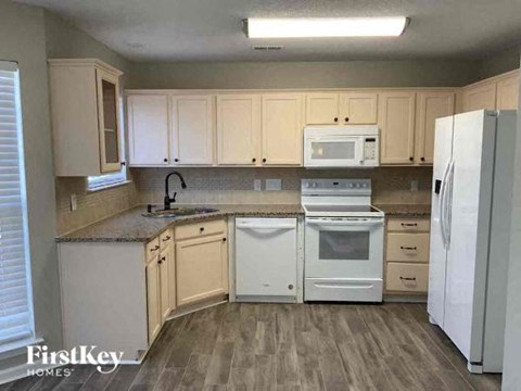 a kitchen with white appliances and white cabinets