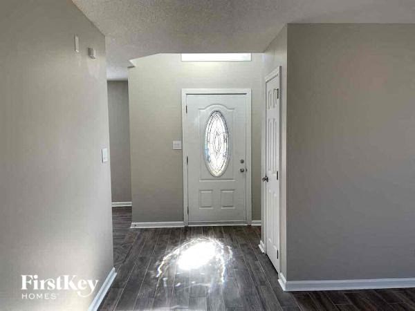 an empty room with a white door and a window