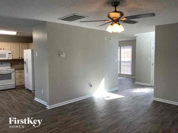 an empty living room with a ceiling fan