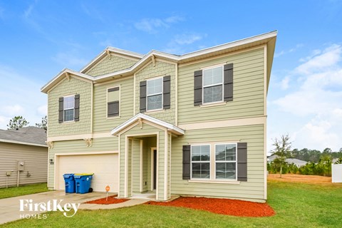 a home with tan siding and a gravel driveway