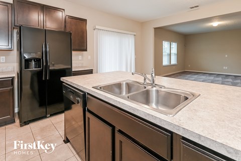 a kitchen with stainless steel appliances and a large counter with a sink