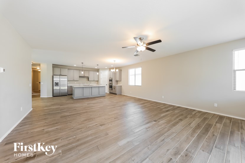 A spacious room with wooden flooring and a ceiling fan.