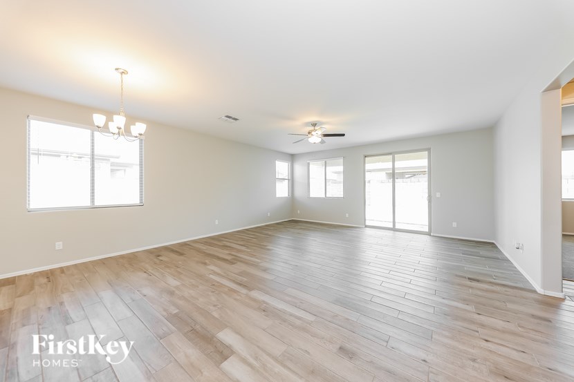 A spacious room with wooden flooring and a ceiling fan.