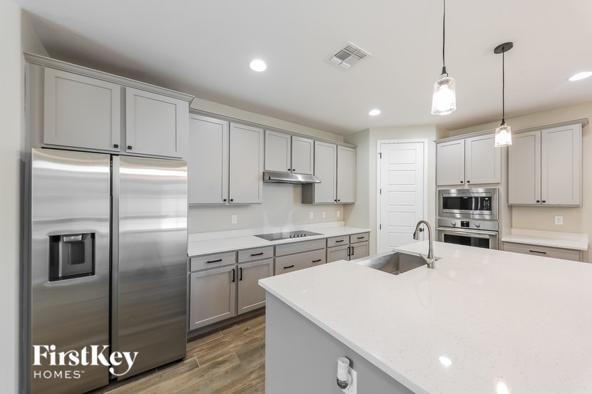A modern kitchen with a stainless steel refrigerator and white countertops.