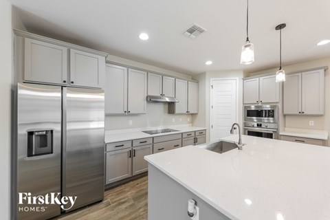 A modern kitchen with a stainless steel refrigerator and white countertops.