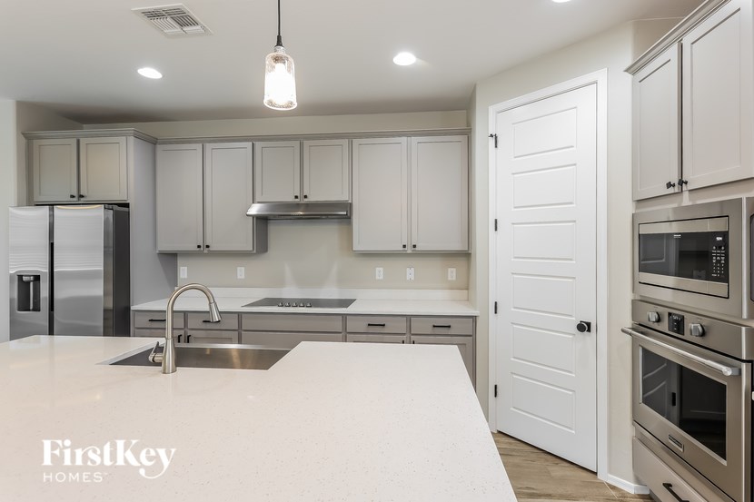 A kitchen with a white counter top and stainless steel appliances.