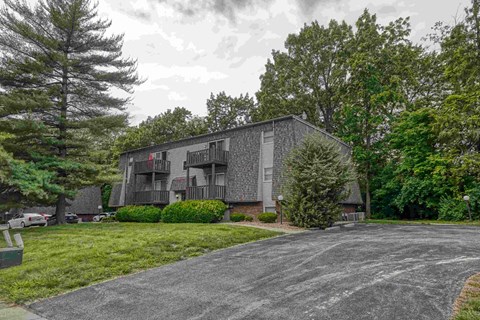 A grey building with a driveway in front of it.