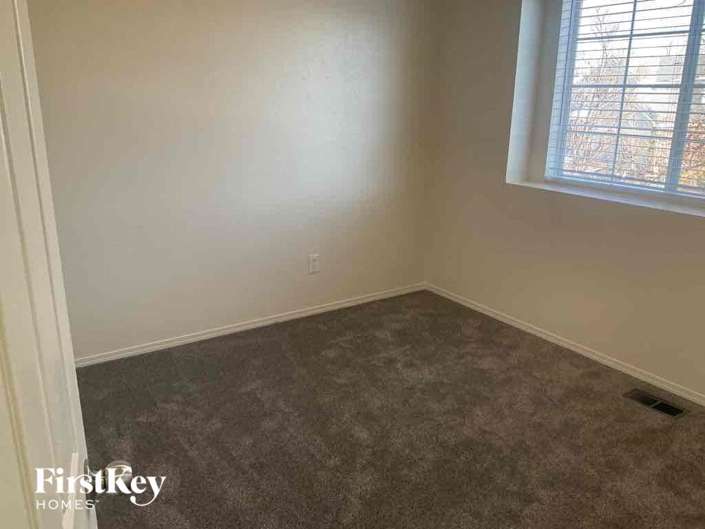 an empty room with a window and a carpet