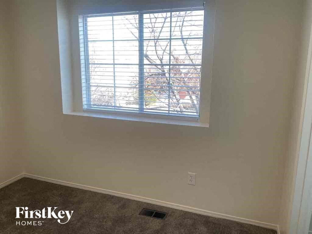 an empty room with a window and a carpet