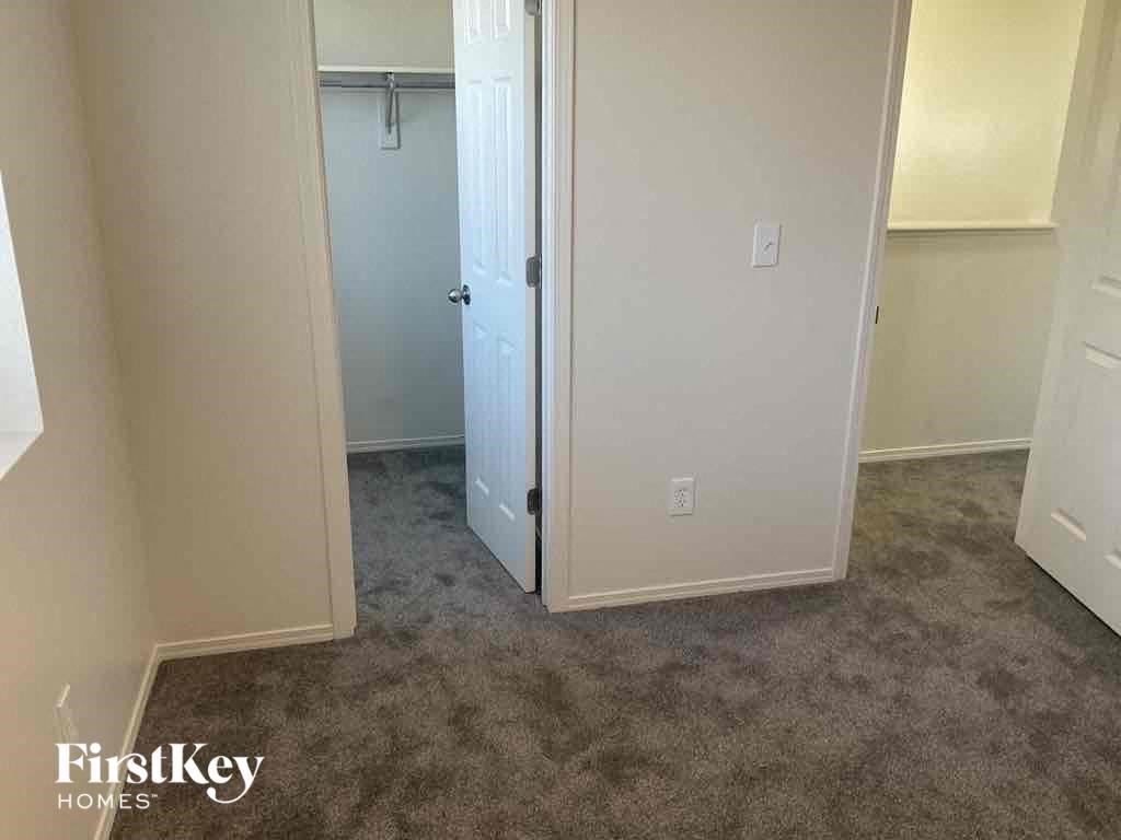 a carpeted room with a closet and an open door