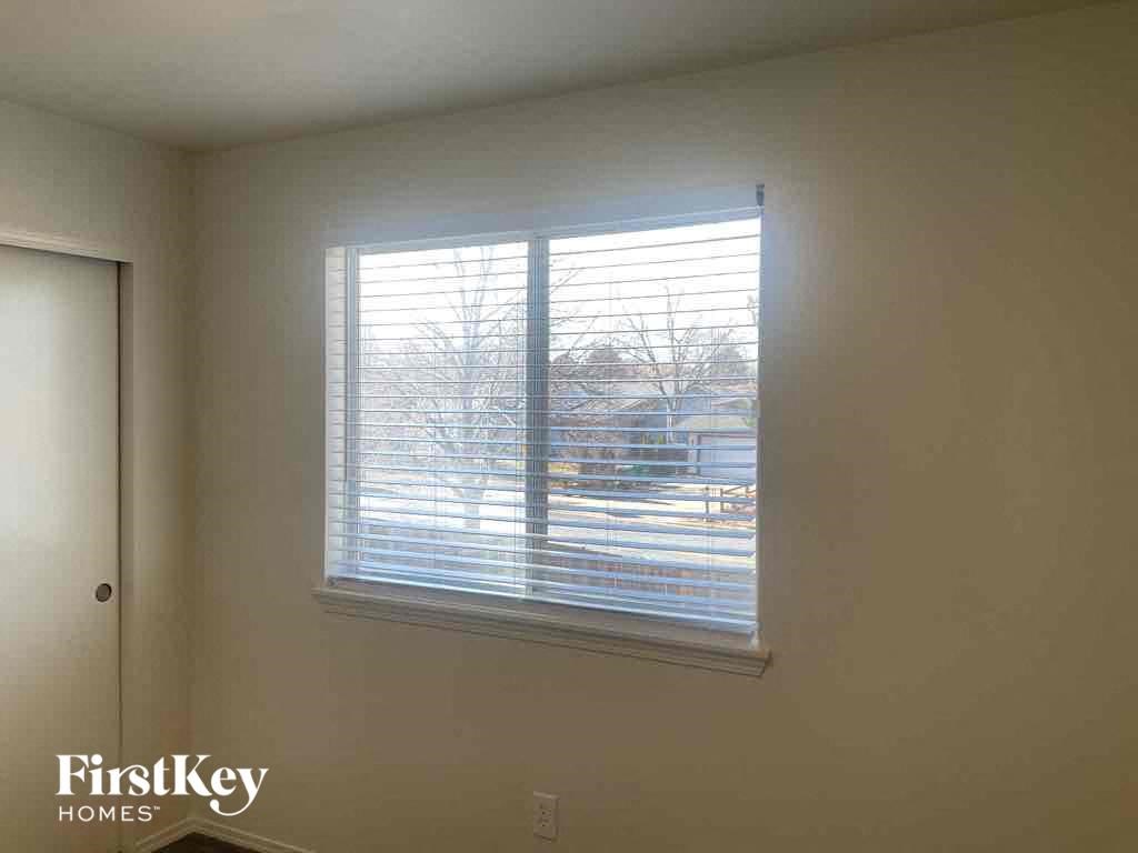 a view of a window with blinds in a white room