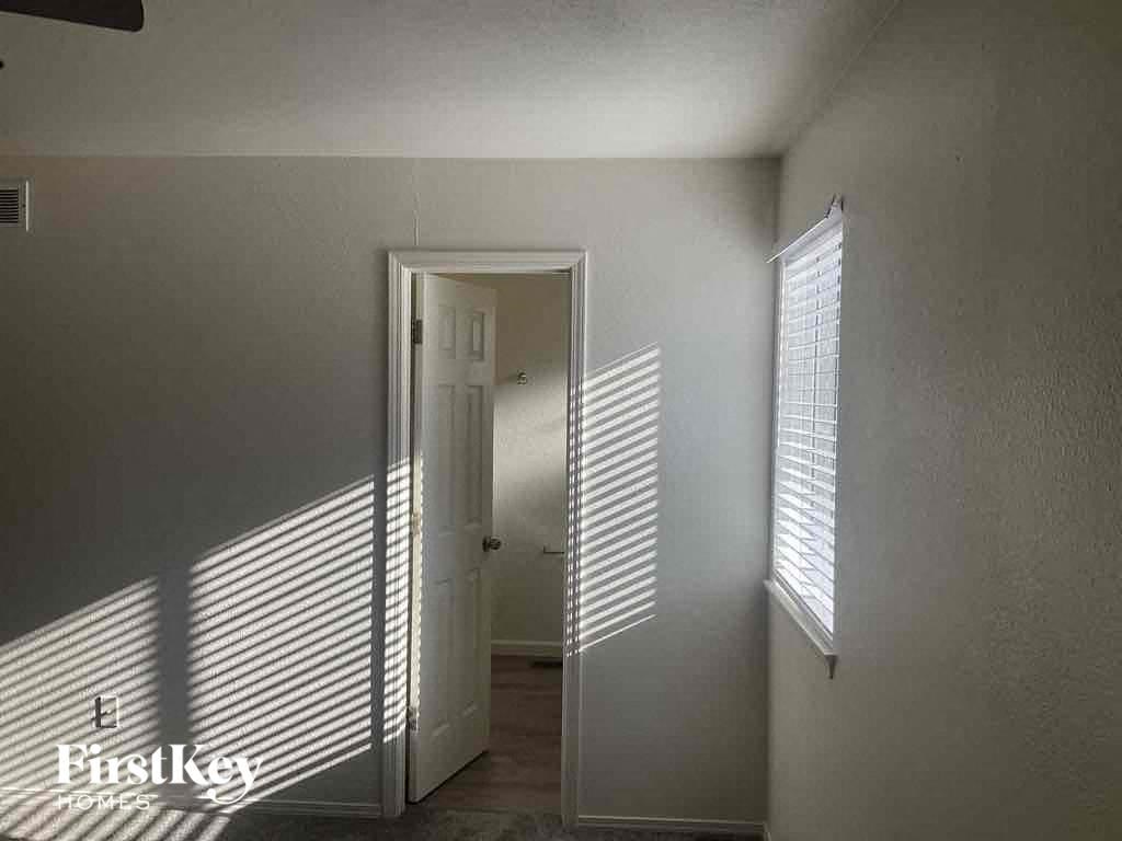 a hallway with a door and a window with shadows on the wall