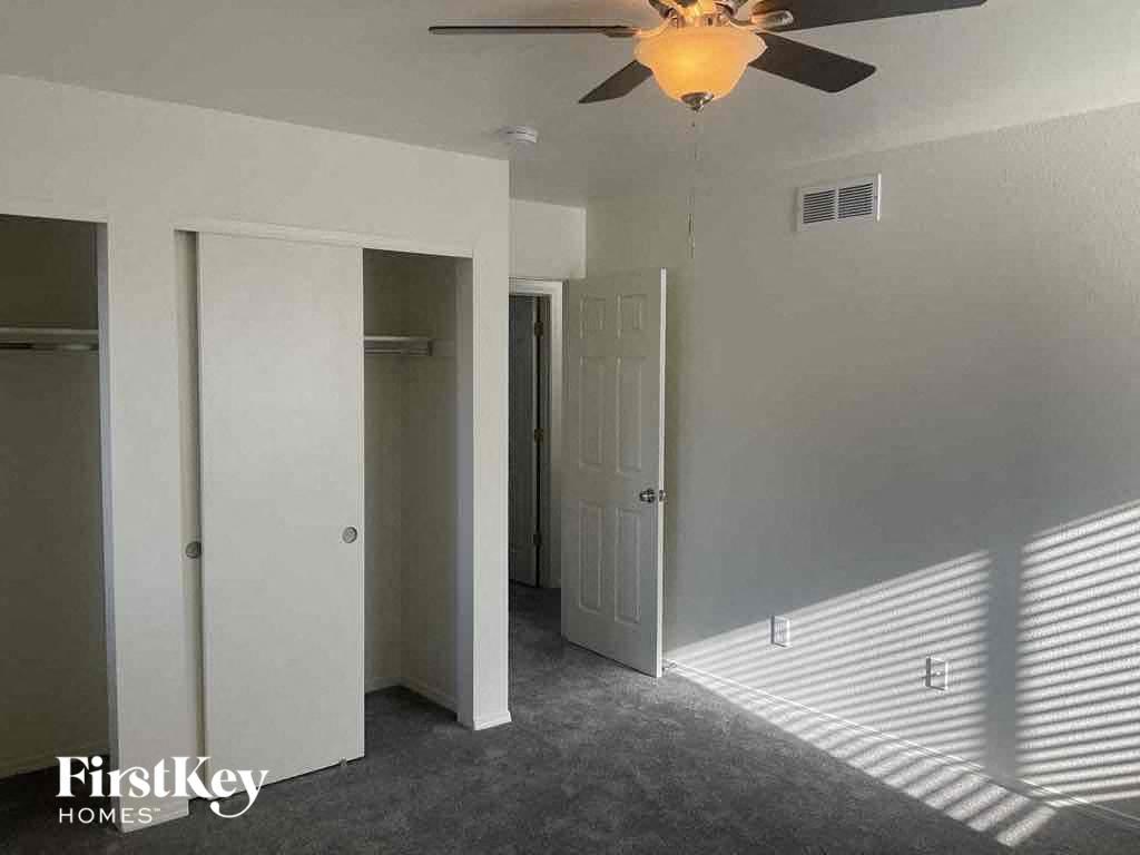 a bedroom with a ceiling fan and a closet