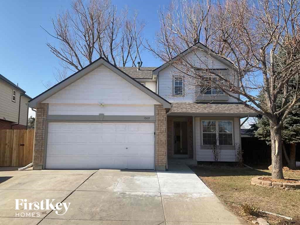 the front of a white house with a white garage door