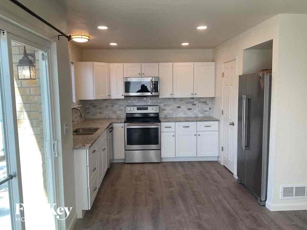 a kitchen with white cabinets and stainless steel appliances