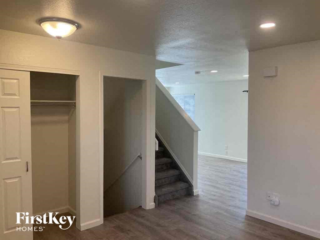 an empty living room with a staircase and a closet
