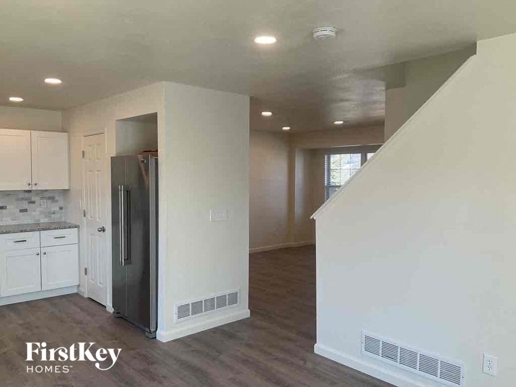 an empty kitchen with a refrigerator and a staircase