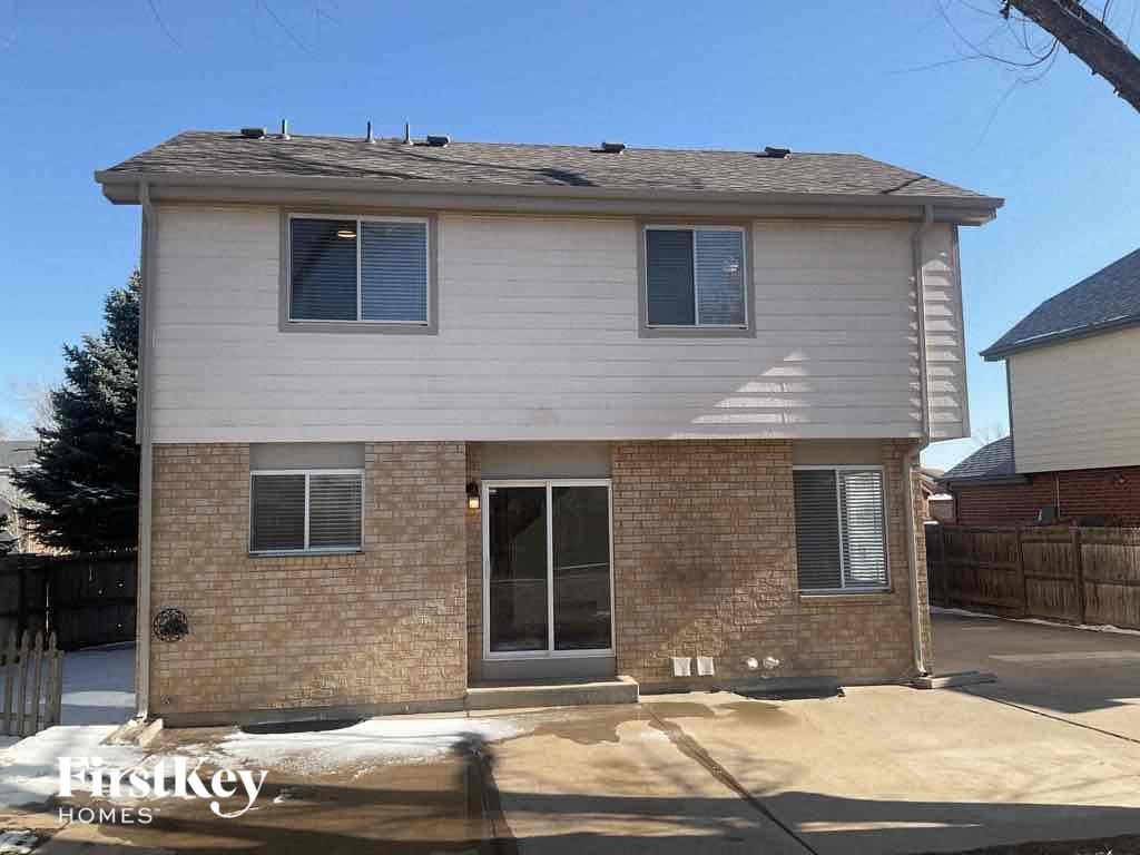 the front of a brick house with a white roof and a glass door
