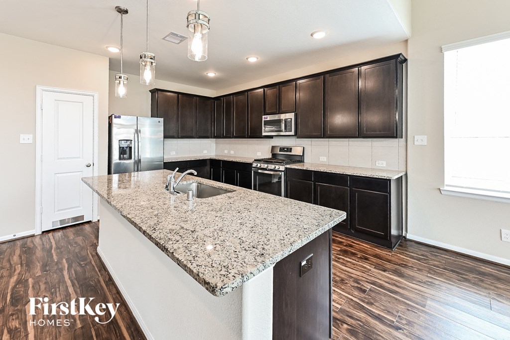 a kitchen with dark wood cabinets and a granite counter top