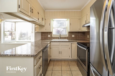 A kitchen with a granite countertop and stainless steel appliances.
