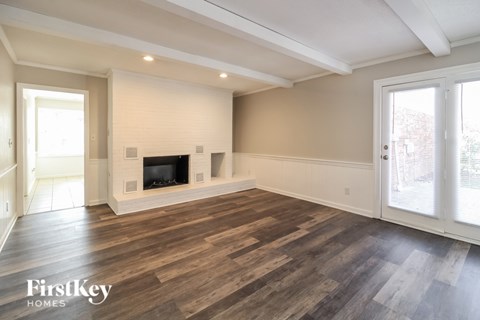 A spacious living room with a fireplace and wooden flooring.