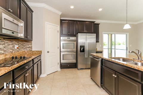 A kitchen with a stove top oven and a refrigerator.