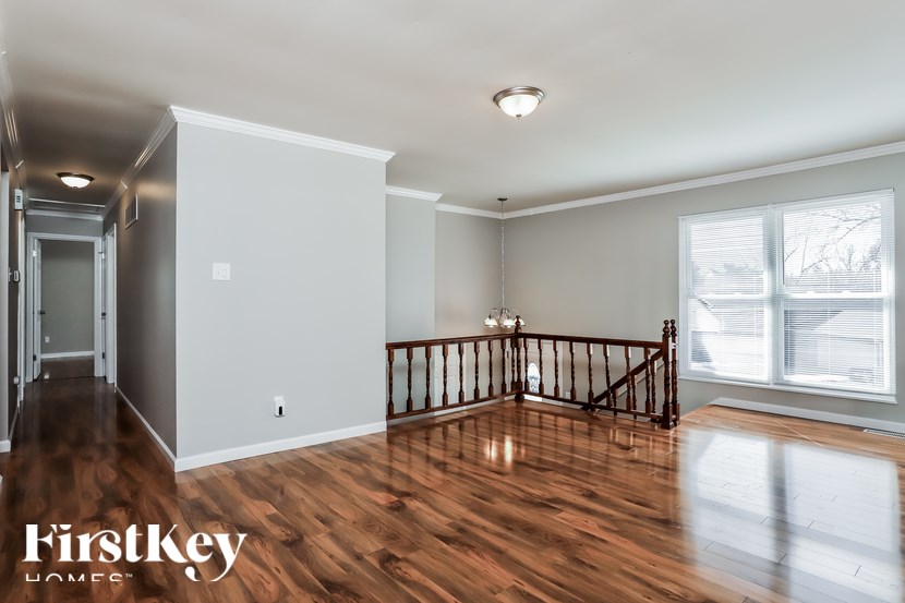 A spacious room with wooden floors and a balcony.