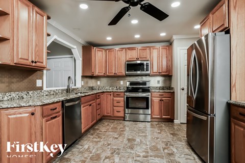 A kitchen with wooden cabinets and a tile floor.