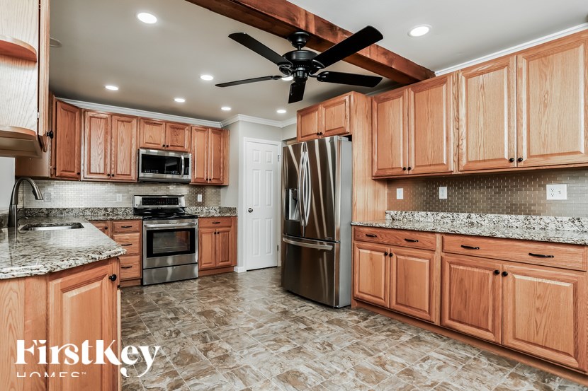 A kitchen with wooden cabinets and a marble countertop.